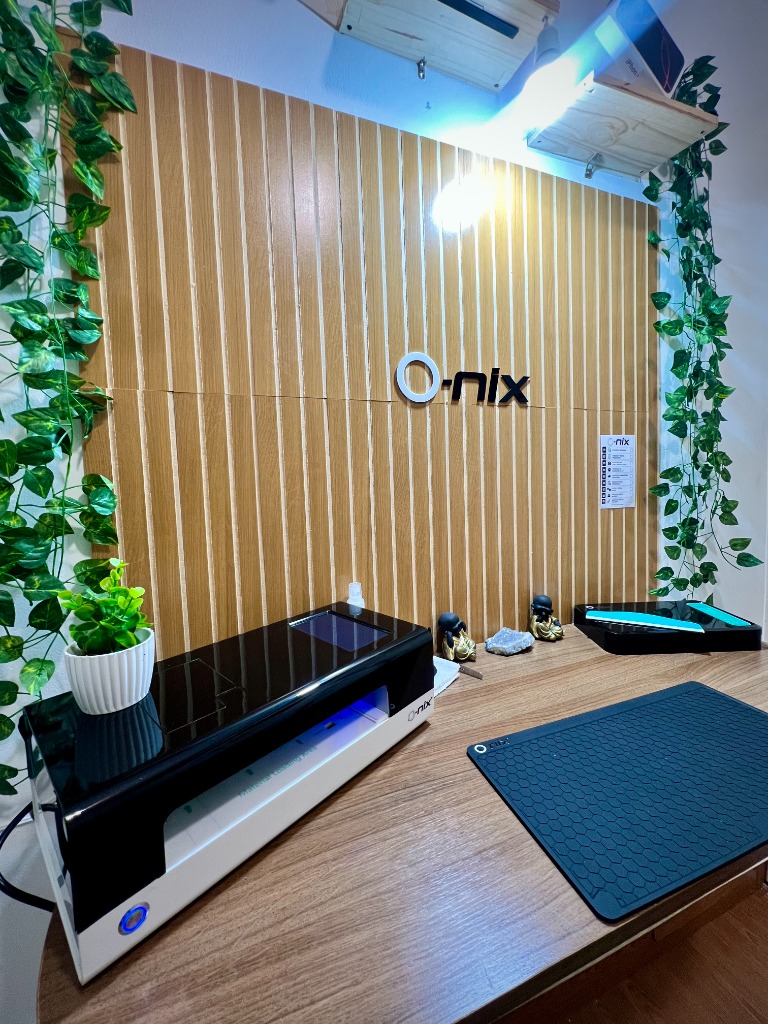 Bancada da Planeta Celular com equipamentos O-nix e logo na parede